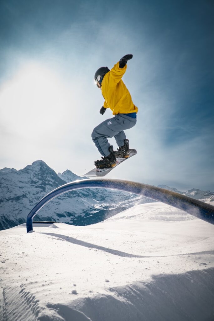 man in yellow jacket and black pants riding on black skateboard during daytime