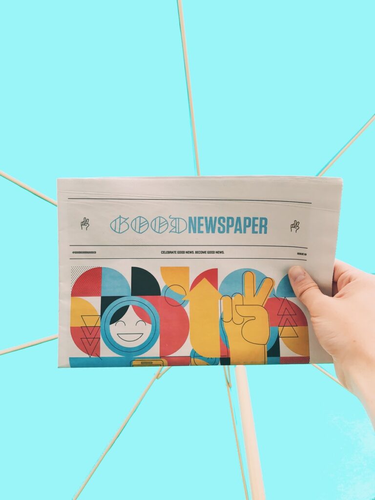 person holding newspaper article